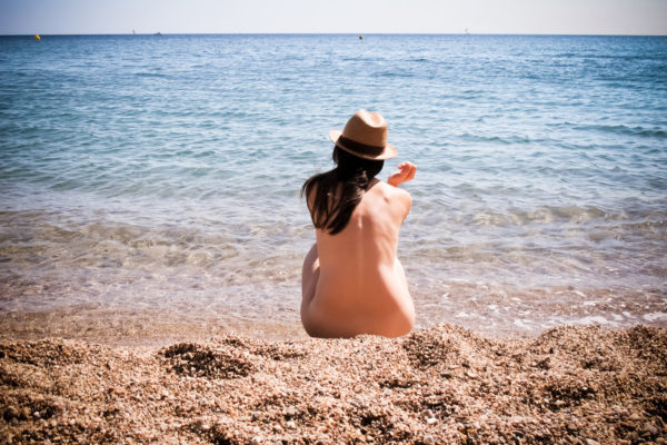 playa - Chica sentada en la arena con sombrero de paja